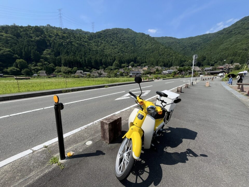 「美山かやぶきの里」をバックに、スーパーカブを撮影