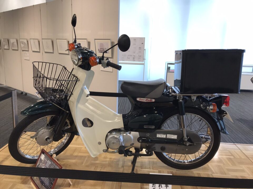 黒のHondaラゲージボックスを取り付けた緑のスーパーカブ